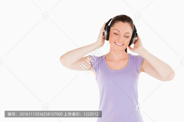 漂亮女人擺著耳機站著