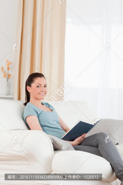漂亮的女人坐在沙發(fā)上看書