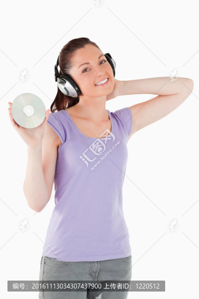漂亮的女人手持耳機(jī)站著CD