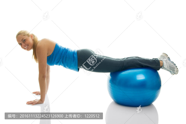 年輕女性對(duì)健身球做俯臥撐