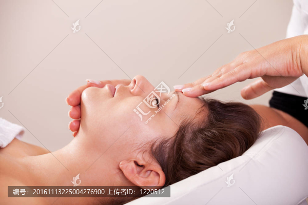 年輕漂亮的女人得到面部按摩