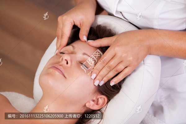 年輕漂亮的女人得到面部按摩