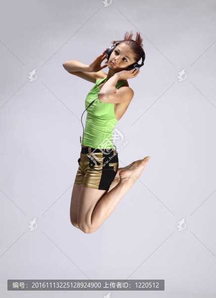 美麗的年輕女孩跳舞和聽音樂