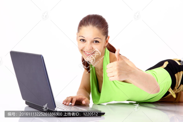 一個年輕女孩坐在沙發(fā)上的筆記本電腦和顯示豎起大拇指的跡象