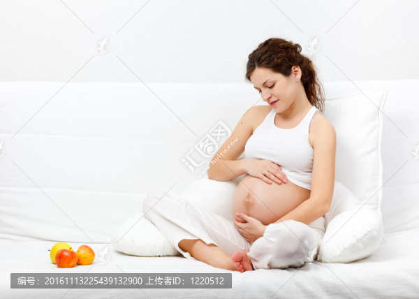 年輕孕婦在沙發(fā)上休閑