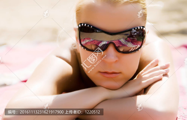 女孩在sunglasseses以太陽浴