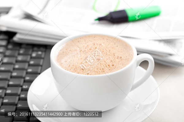 隨著筆記本電腦和新聞的卡布奇諾咖啡杯