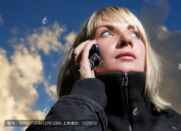 女孩在電話里通過藍色多云天空
