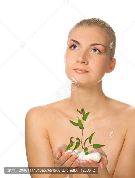 美麗的金發(fā)女孩抱著年輕的植物通過石頭長大
