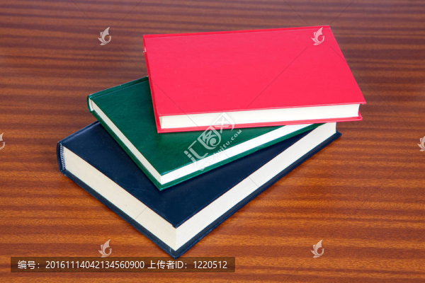 木制表面上的三本精裝書