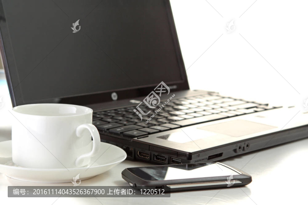 在筆記本電腦上的一杯咖啡和一支鋼筆