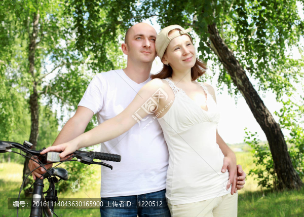 年輕夫婦在公園里的自行車上