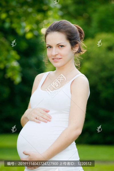 美麗的孕婦在公園里放松