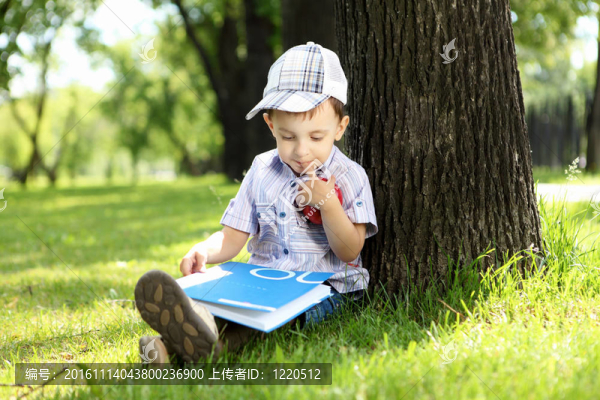 一個(gè)男孩在公園里拿著一本書的肖像