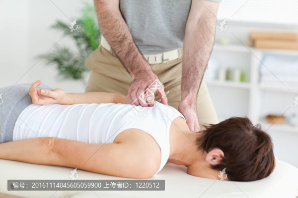 按摩師按摩一個(gè)黑發(fā)女人的肩膀