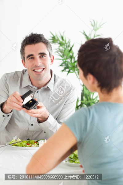 微笑的男人在晚餐時向他的女朋友求婚
