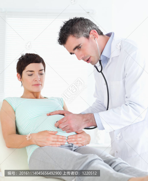 醫(yī)生聽進(jìn)女人的肚子用聽診器