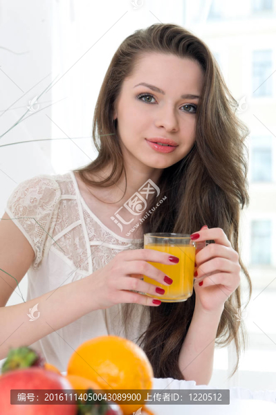 美麗的女人正在喝橙汁