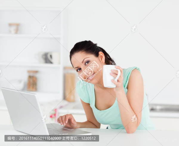 微笑的年輕女子與咖啡的筆記本電腦