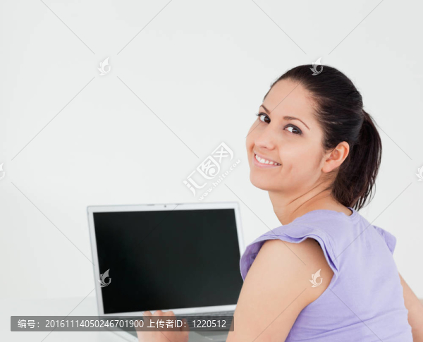 微笑的年輕女子坐在筆記本電腦