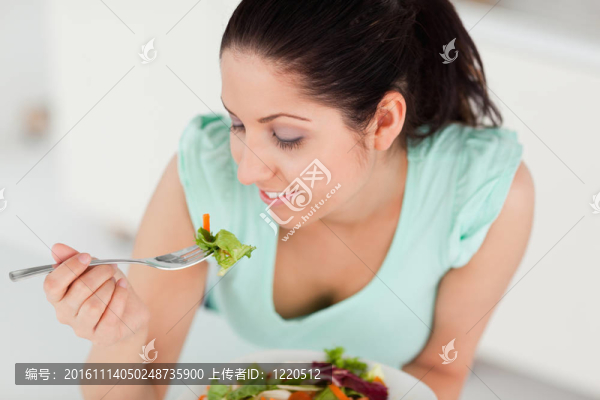 美麗的年輕女人吃沙拉