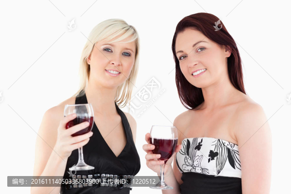 迷人的穿著考究的女性飲用紅葡萄酒