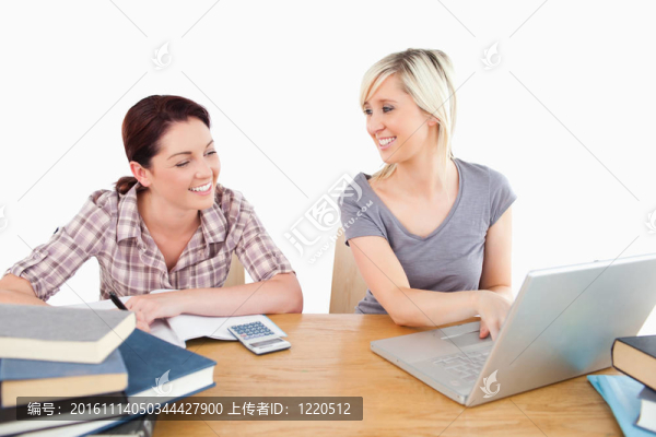 可愛(ài)的女人學(xué)習(xí)筆記本電腦和書(shū)籍