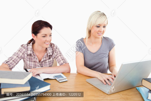 可愛的女人在餐桌上學(xué)習(xí)