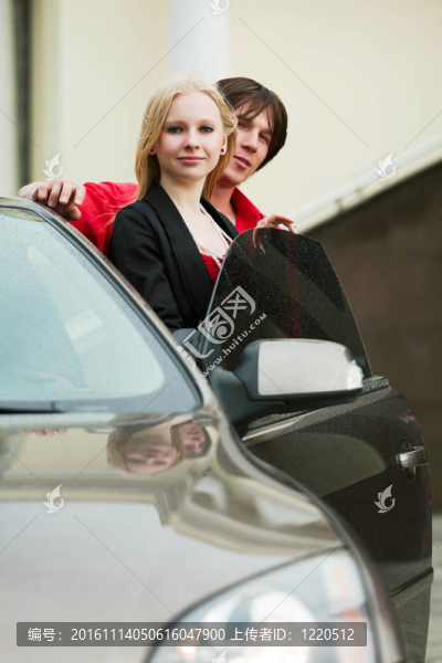 一對年輕夫婦帶著一輛新車