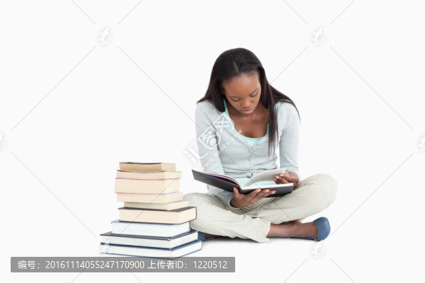 年輕女子閱讀旁邊的一疊書