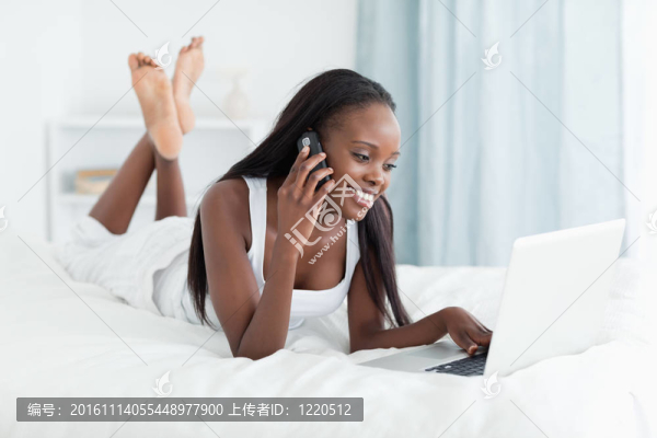 在打電話時用筆記本電腦的快樂女人