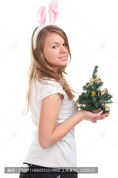 女孩裝扮成兔子，手里拿著圣誕樹
