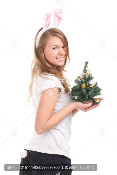 女孩裝扮成兔子，手里拿著圣誕樹(shù)