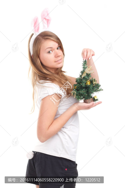 女孩裝扮成兔子，手里拿著圣誕樹