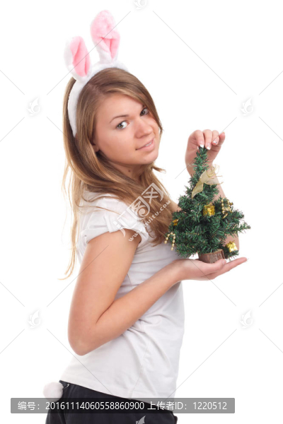 女孩裝扮成兔子，手里拿著圣誕樹(shù)