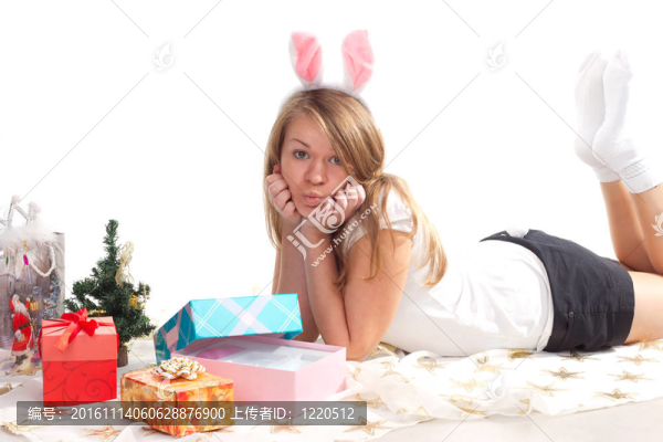 躺在圣誕禮物旁邊的女孩