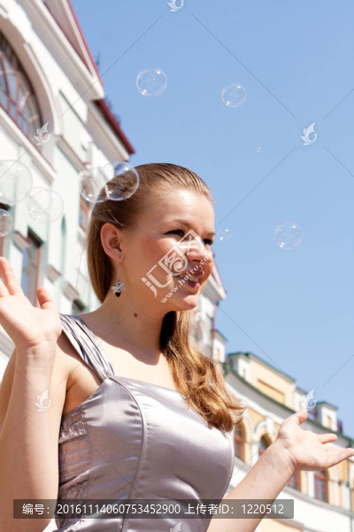 美麗的女孩與肥皂泡對天空的背景
