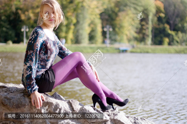 在秋天的紫色緊身衣的漂亮女孩