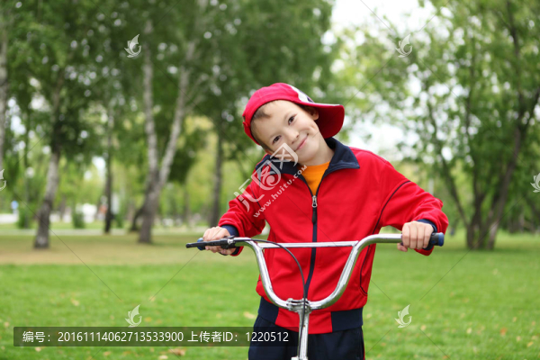 在綠色公園里騎自行車的男孩