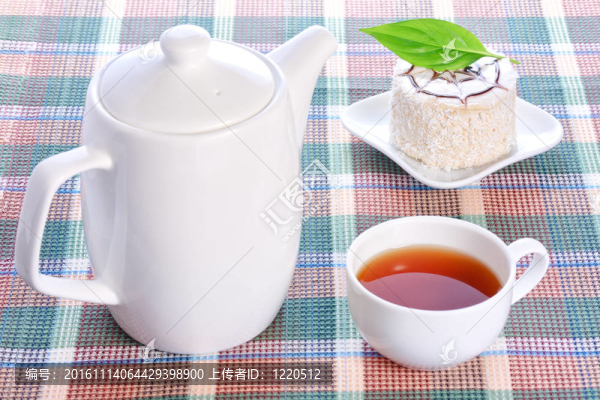 牛奶果凍蛋糕，綠葉子和椰子裝飾在一個白色的盤子；茶壺和一杯茶
