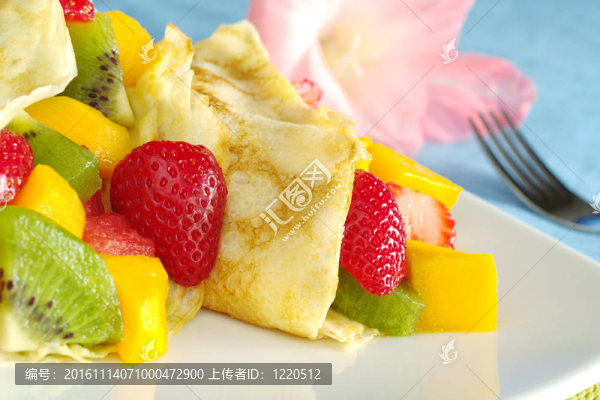 充滿了新鮮的水果可麗餅（草莓；獼猴桃；芒果；西瓜）和粉紅的劍蘭和背景中叉（選擇性焦點；聚焦草莓半縐）
