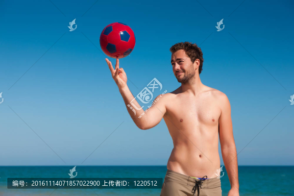 男子在沙灘上平衡足球