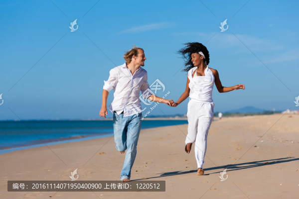 夫婦在海灘上散步和跑步