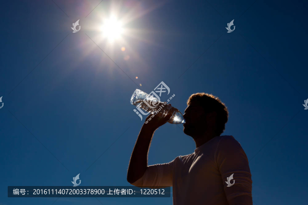 男子在陽光下喝瓶裝水