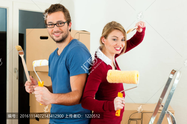 年輕夫婦在家里或公寓里搬家；他們正在油漆和做裝修工作