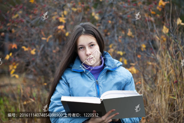 一個(gè)女孩，她的頭發(fā)讀一本書(shū)