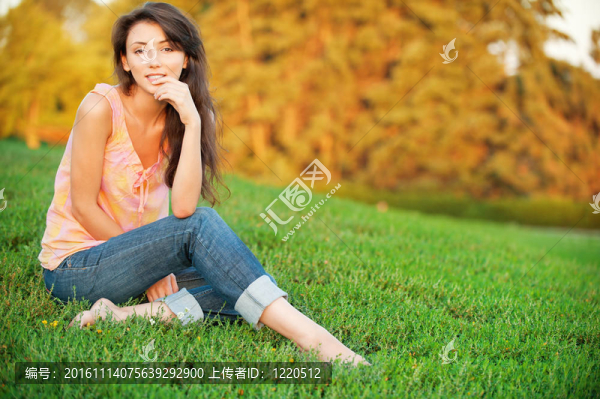 女人坐在綠色的草地上