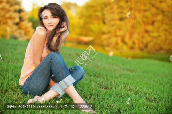 女人坐在綠色的草地上