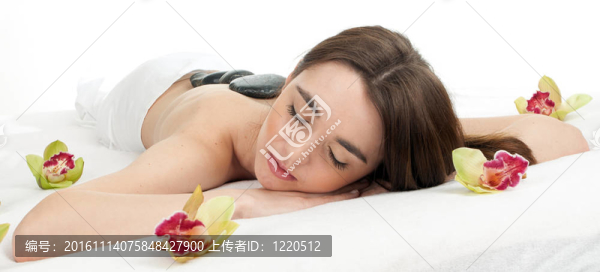 美麗的年輕女子在水療院；石頭按摩