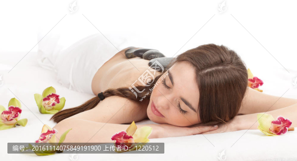 美麗的年輕女子在水療院；石頭按摩